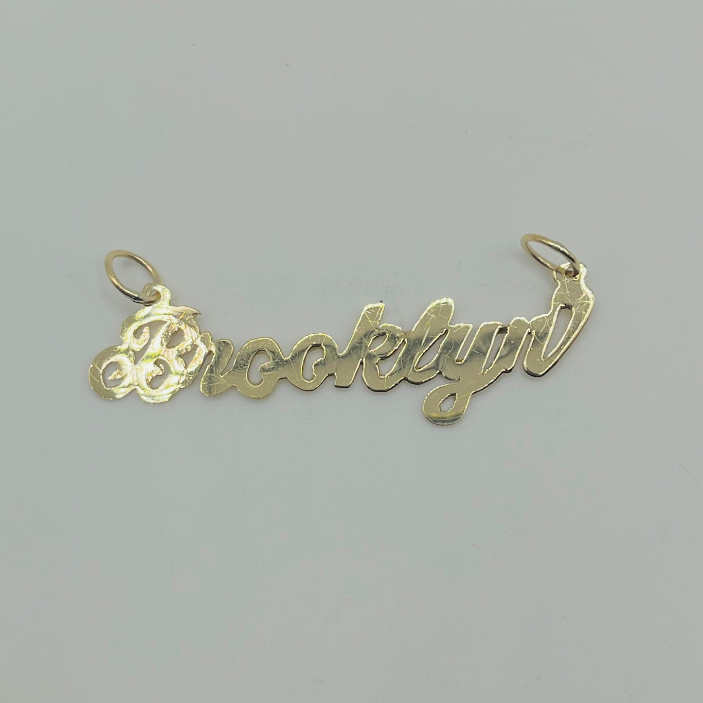 A 10K gold high polish nameplate necklace with the name 'Brooklynn' written in cursive script.