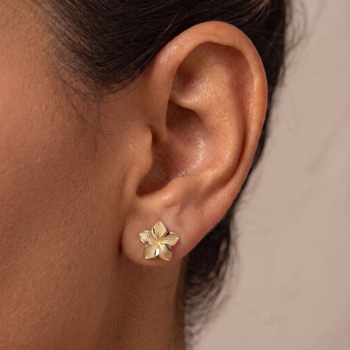 Closeup of 10K Gold Hibiscus Earrings on Model Ear