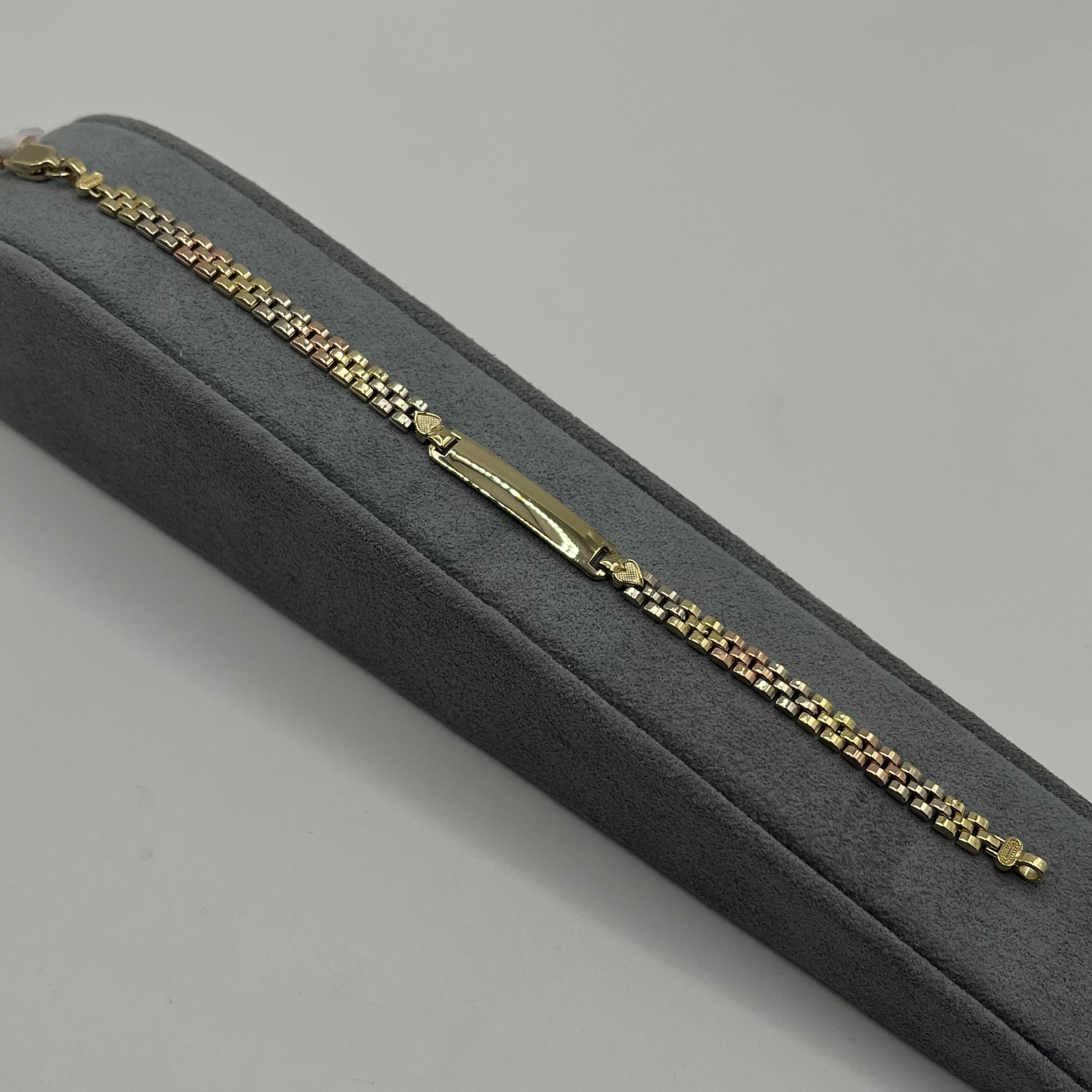 Gold bracelet on a gray cushioned box