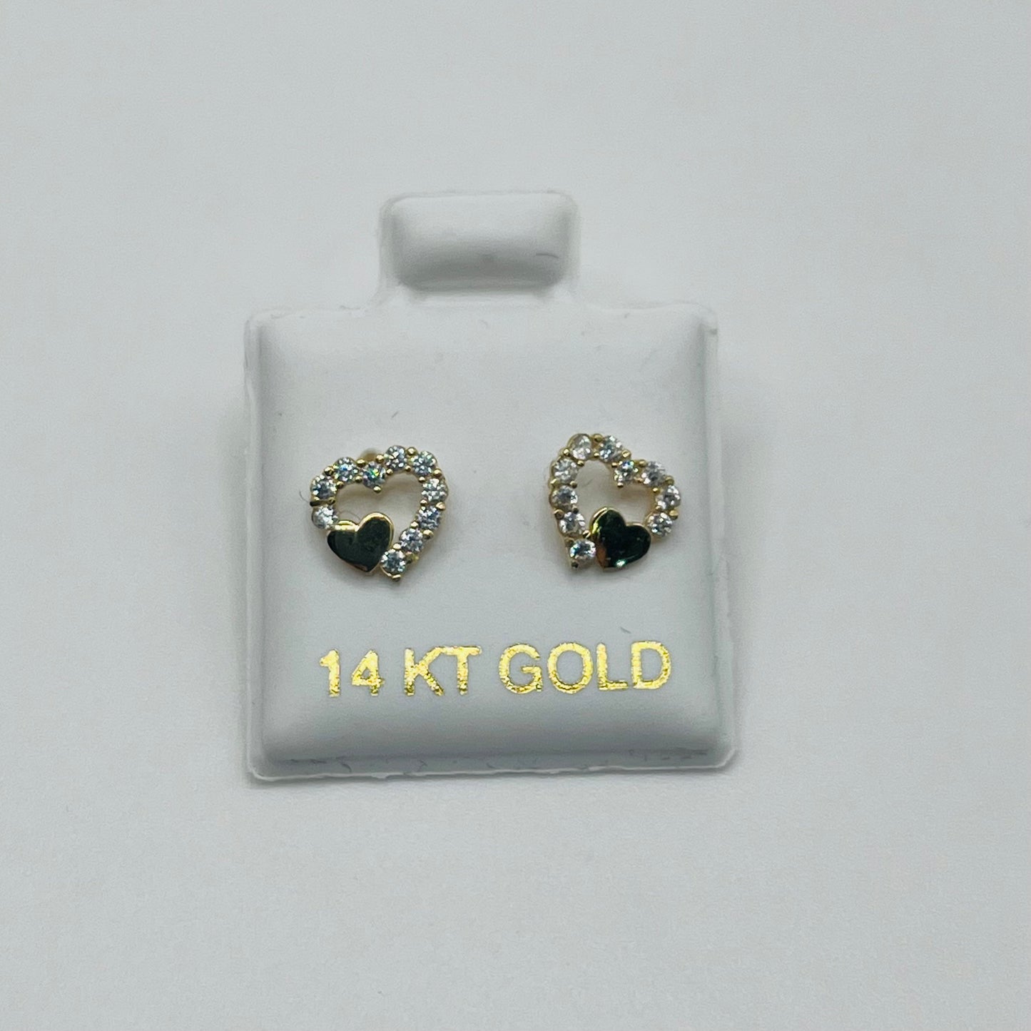 Pair of gold heart-shaped earrings with black centers on a white card labeled '14 KT GOLD'.