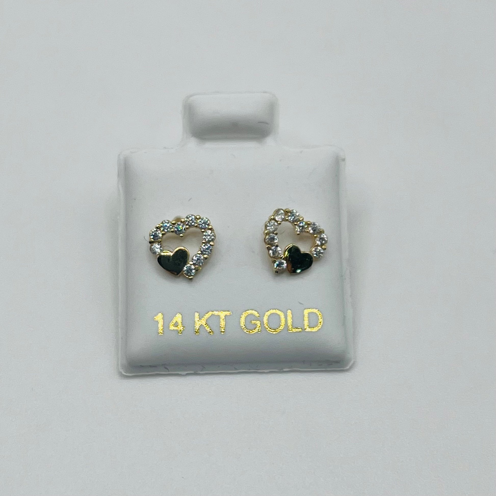 Pair of gold heart-shaped earrings with black centers on a white card labeled '14 KT GOLD'.
