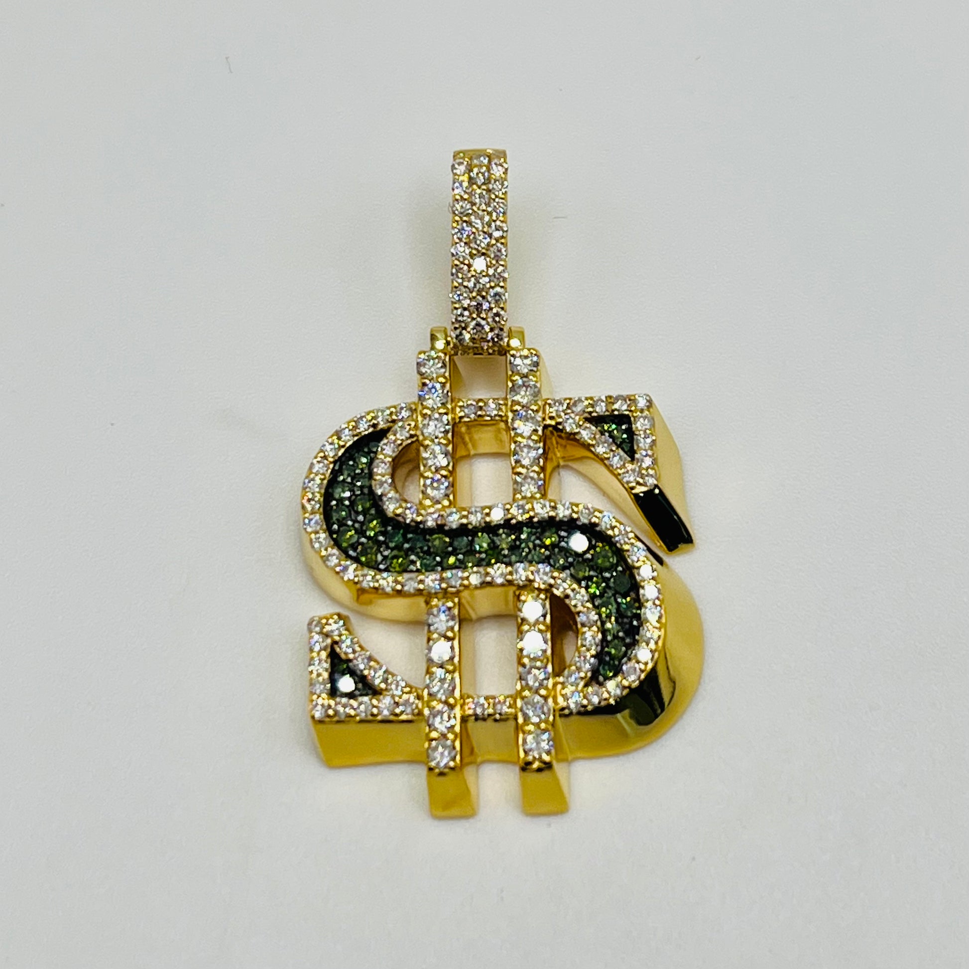 Gold pendant with dollar sign design on a light gray background