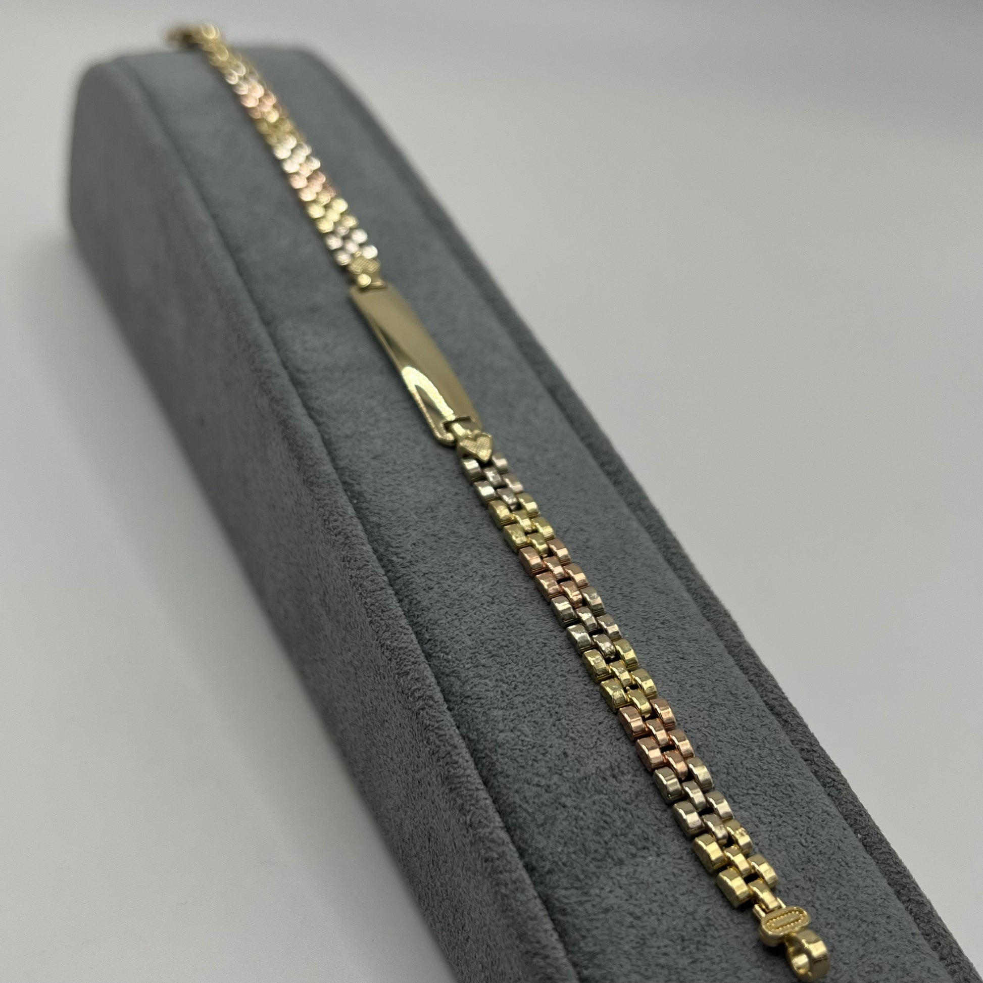 Gold chain bracelet on a gray cushioned box