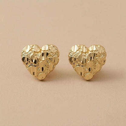 A pair of 10K Gold Medium Heart Shaped Nugget Earrings on a solid beige background.