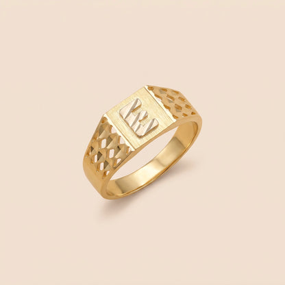 A 10K Gold Square Initial Ring with a geometric, faceted design and a textured center, displayed on a solid light beige background.