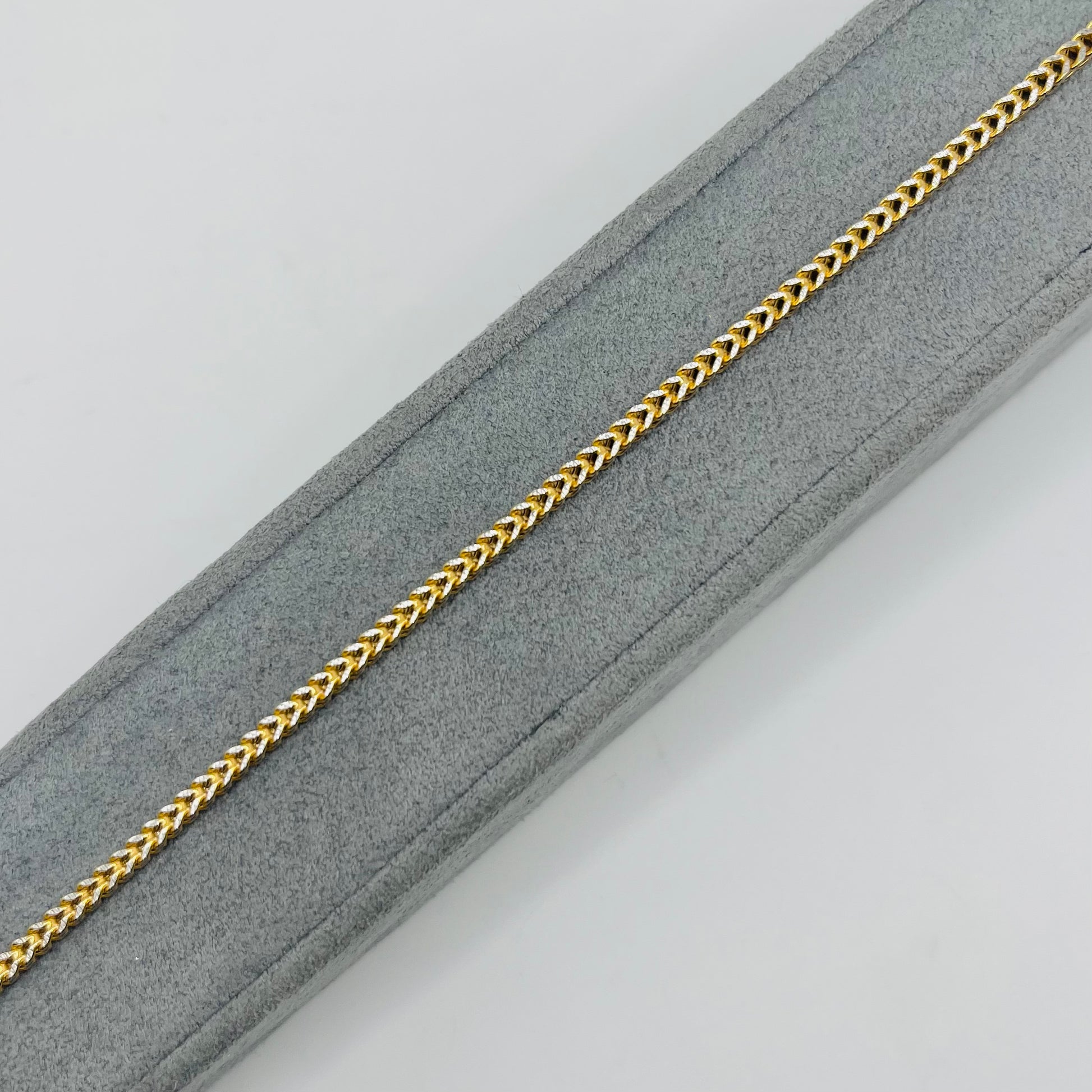 10K gold franco bracelets with diamond cuts on a gray jewelry stand with white background