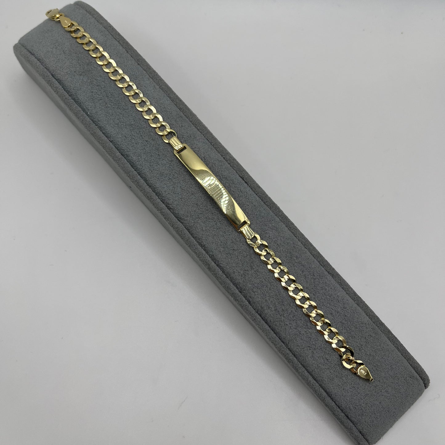Gold chain in a gray jewelry box on a light gray background