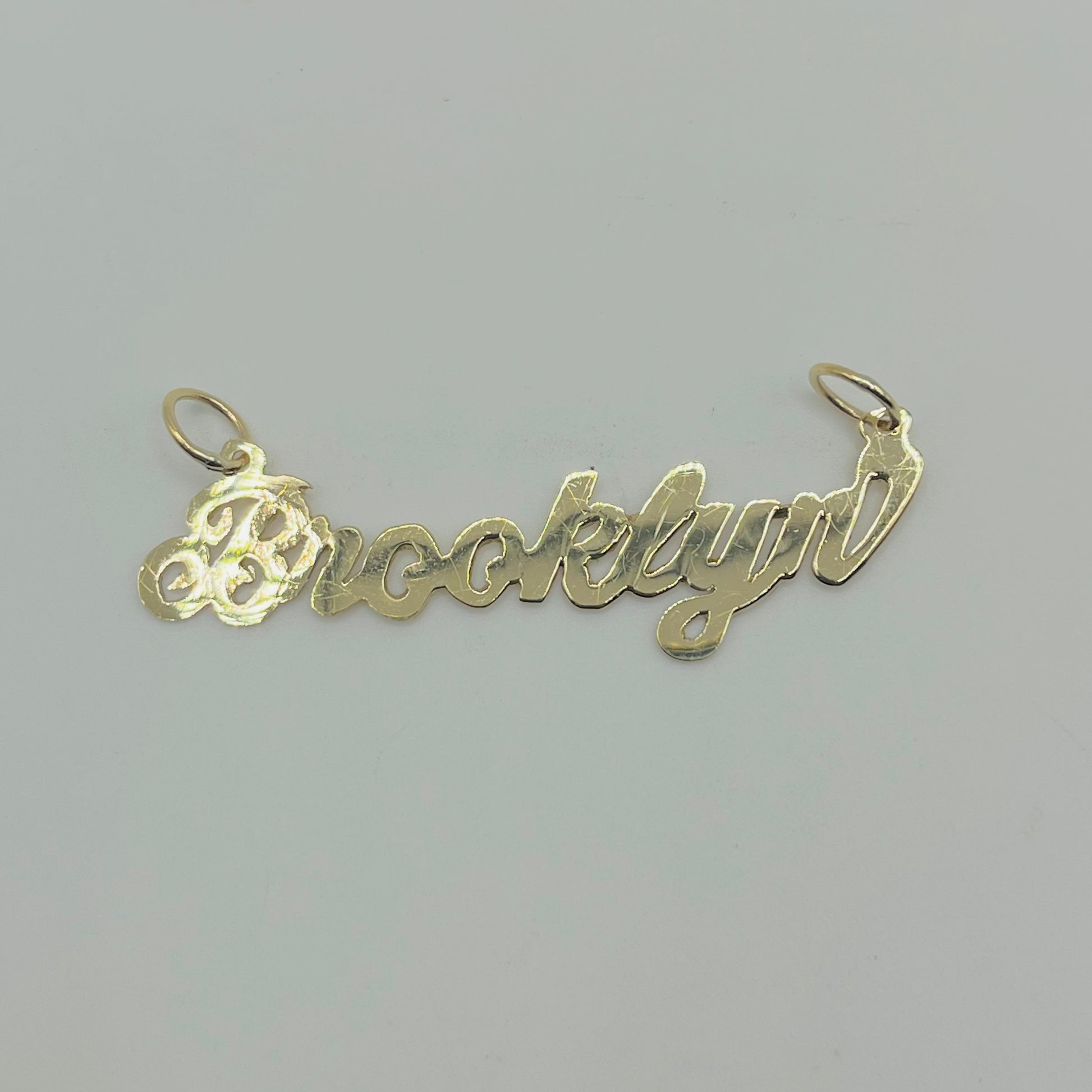 A 10K gold high polish nameplate necklace with the name 'Brooklynn' written in cursive script.