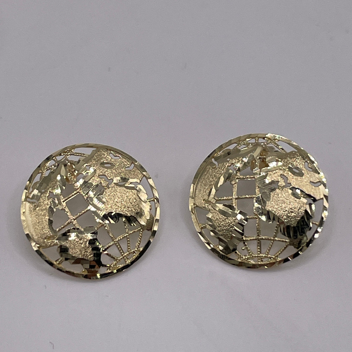 A pair of 10K gold globe earrings with intricate detailing, displayed against a grey background.