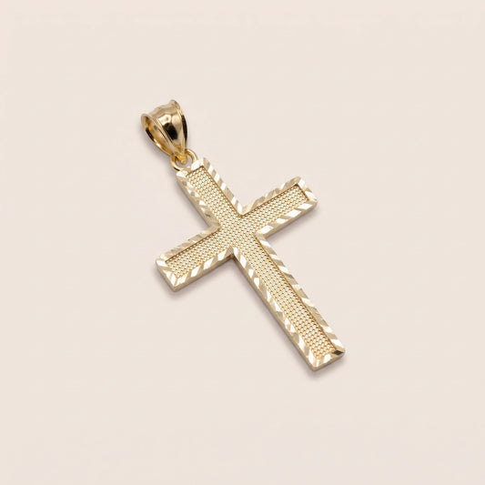 A 10k gold ribbed classic cross charm against a biege background.