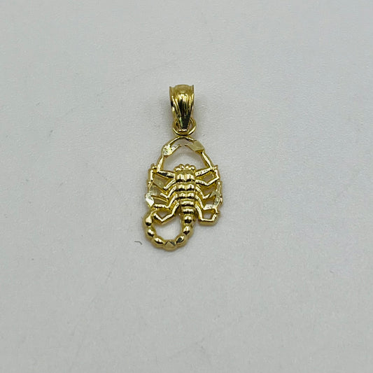 Gold scorpion pendant on a light gray background