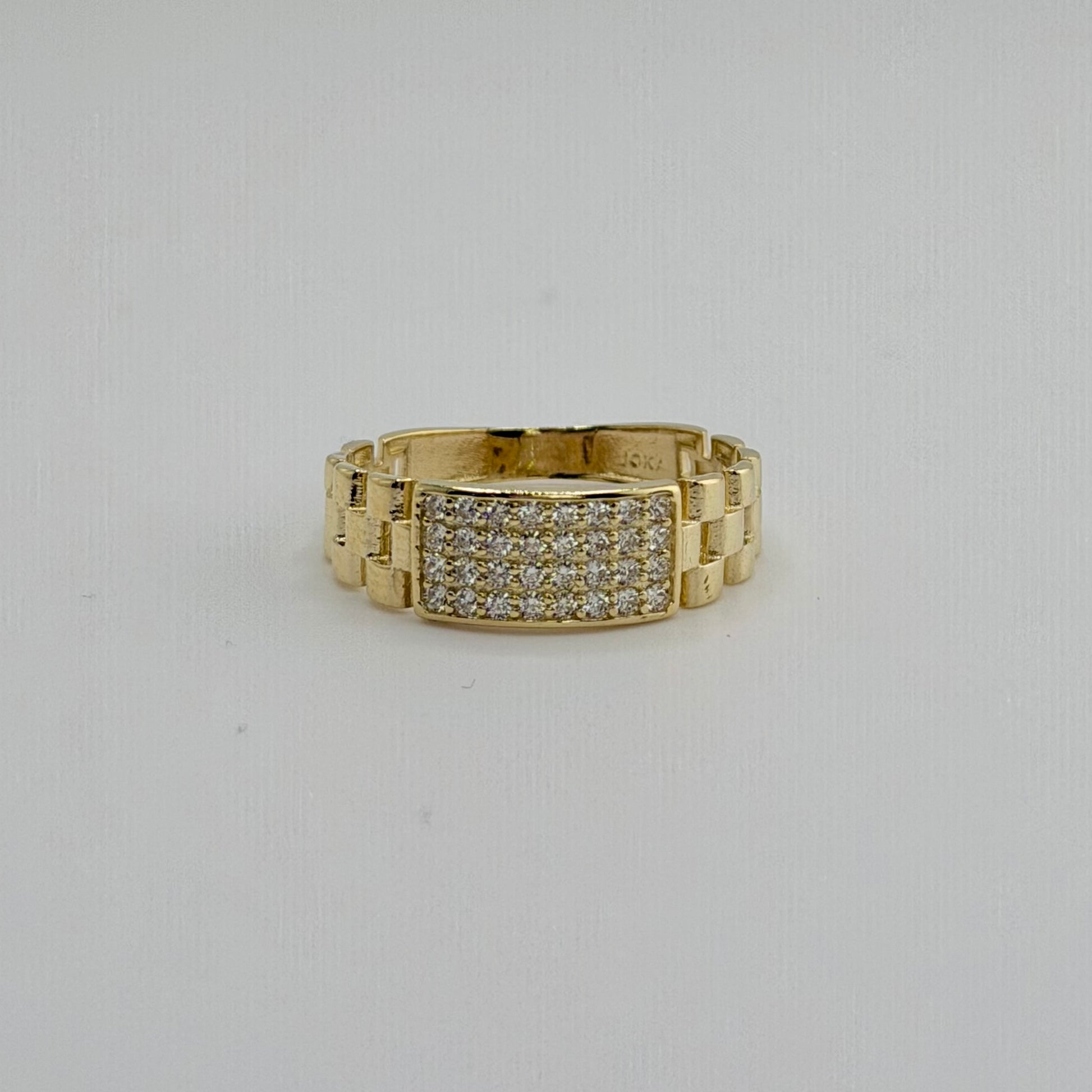 Gold ring with diamond accents on a light gray background