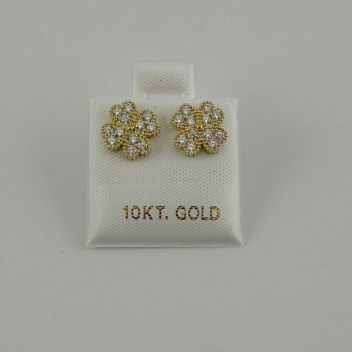 Gold earrings with gemstones on a 10K gold card against a gray background