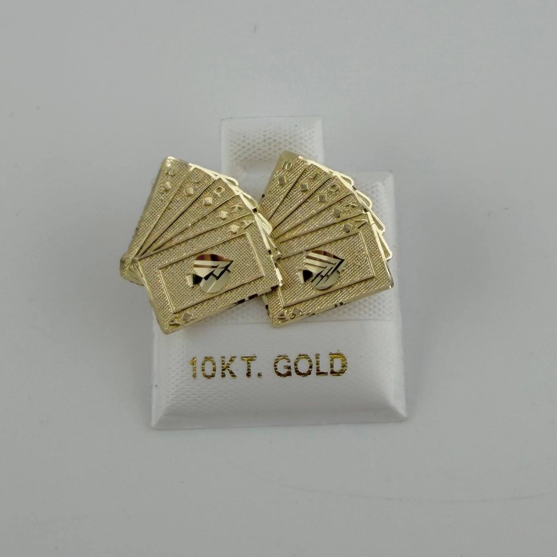 Gold playing card cufflinks on a 10K gold label against a gray background