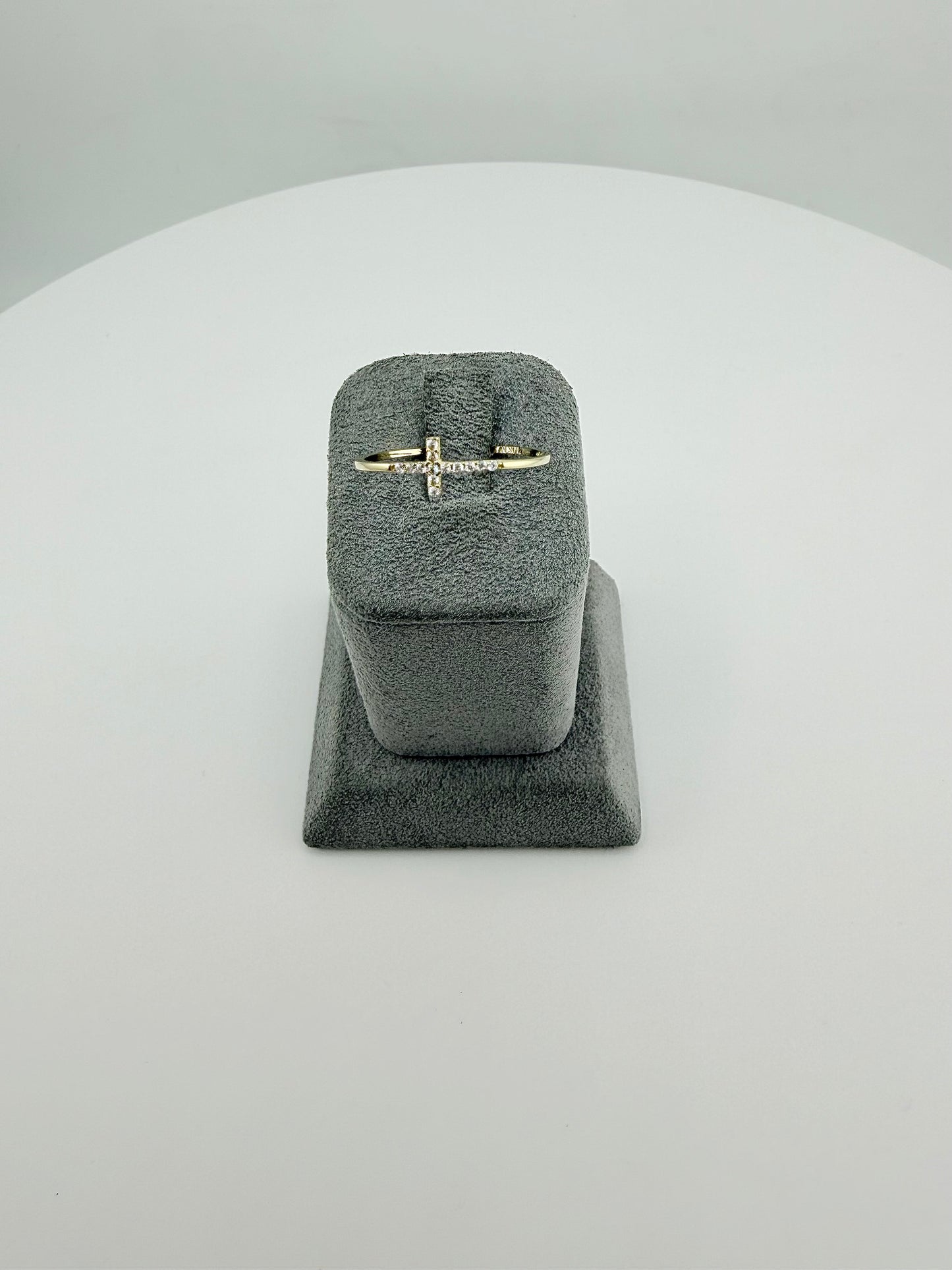 Gold ring in a gray velvet ring box on a light gray background