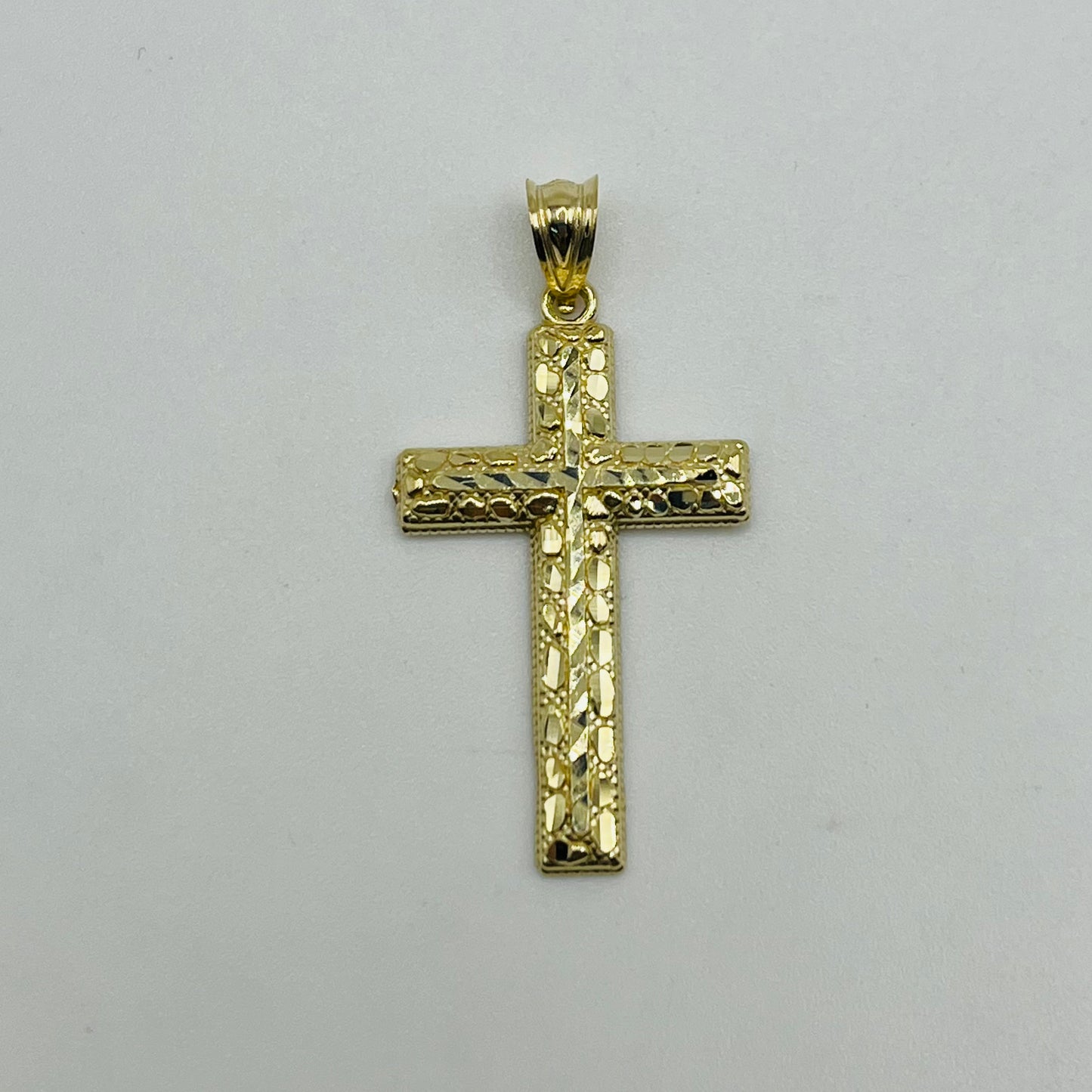 Gold cross pendant on a light gray background