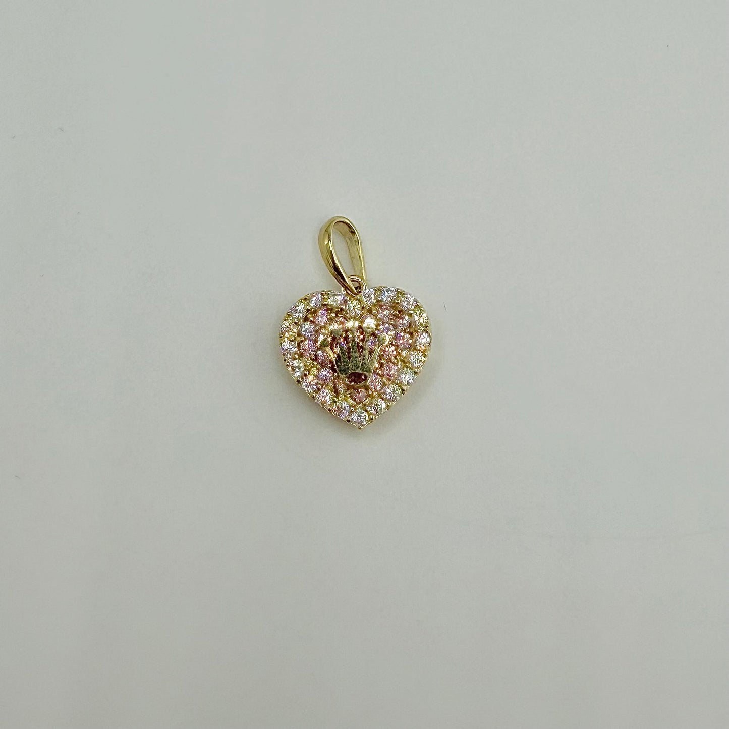 Heart-shaped pendant with pink and gold accents on a light gray background