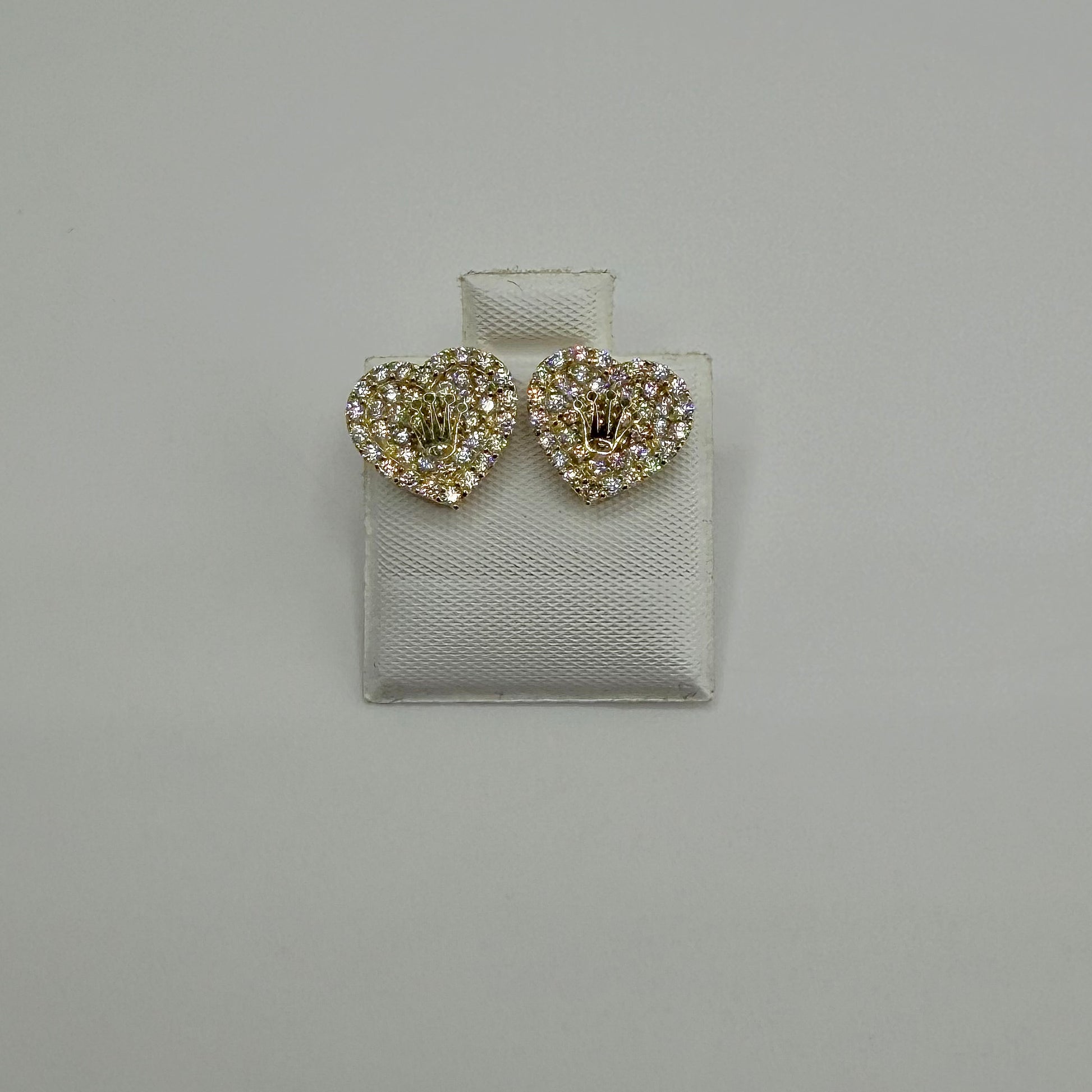 Heart-shaped earrings with rhinestones on a gray background