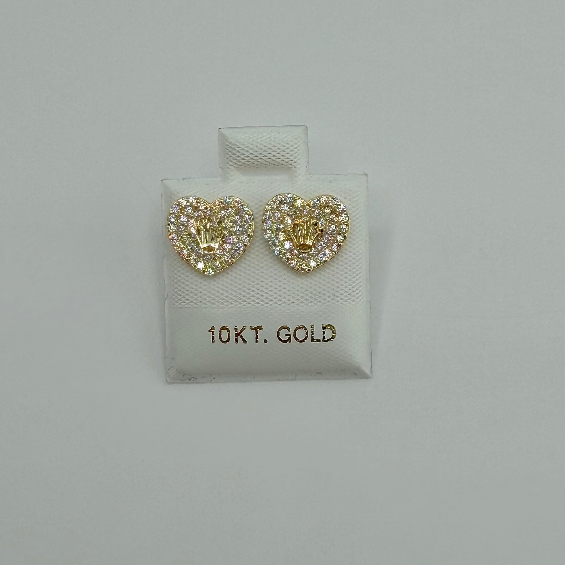 Heart-shaped gold earrings with '10KT. GOLD' label on a light gray background