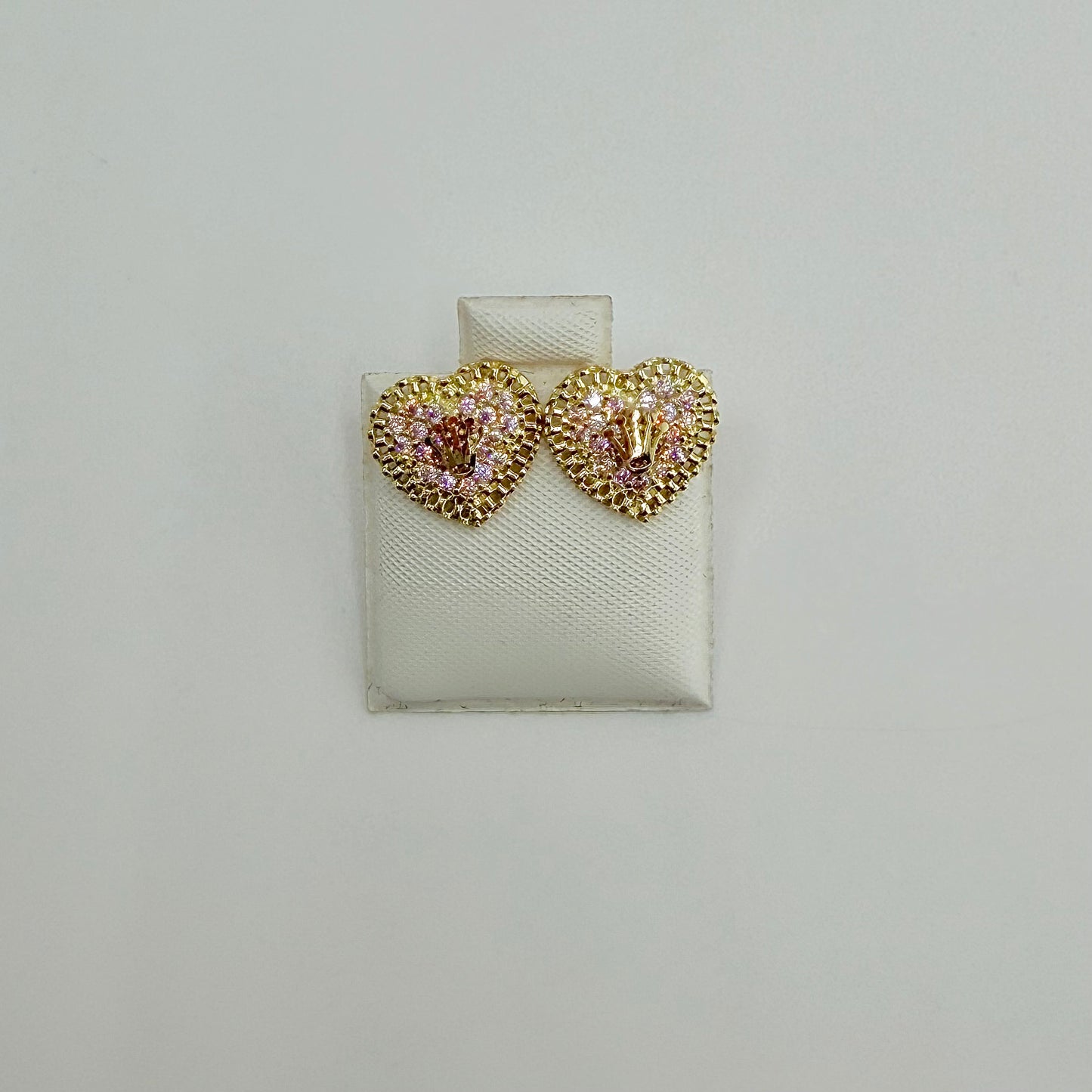 Heart-shaped earrings with gemstones on a white display card against a light gray background