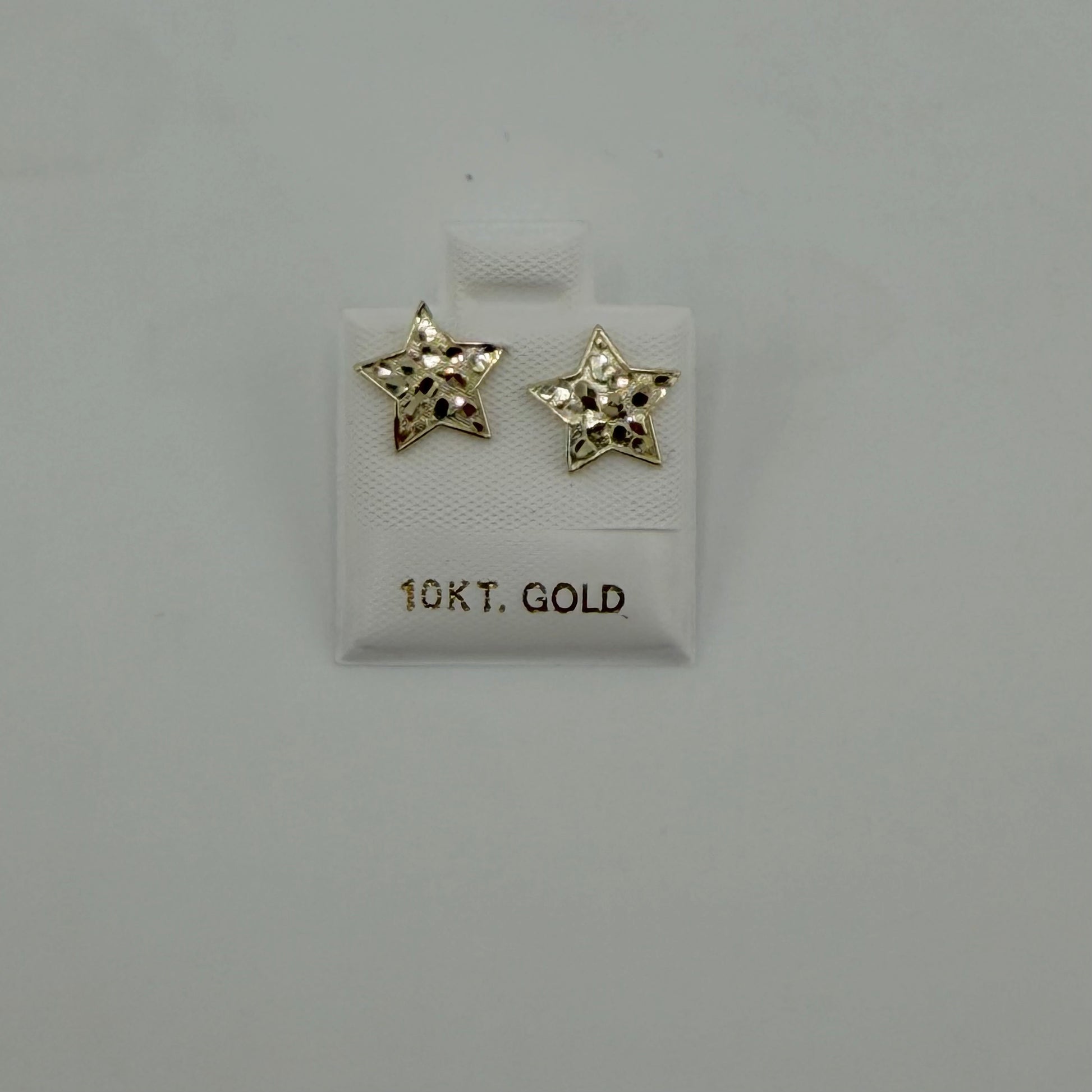 Star-shaped gold earrings on a gray background with '10Kt. Gold' label.