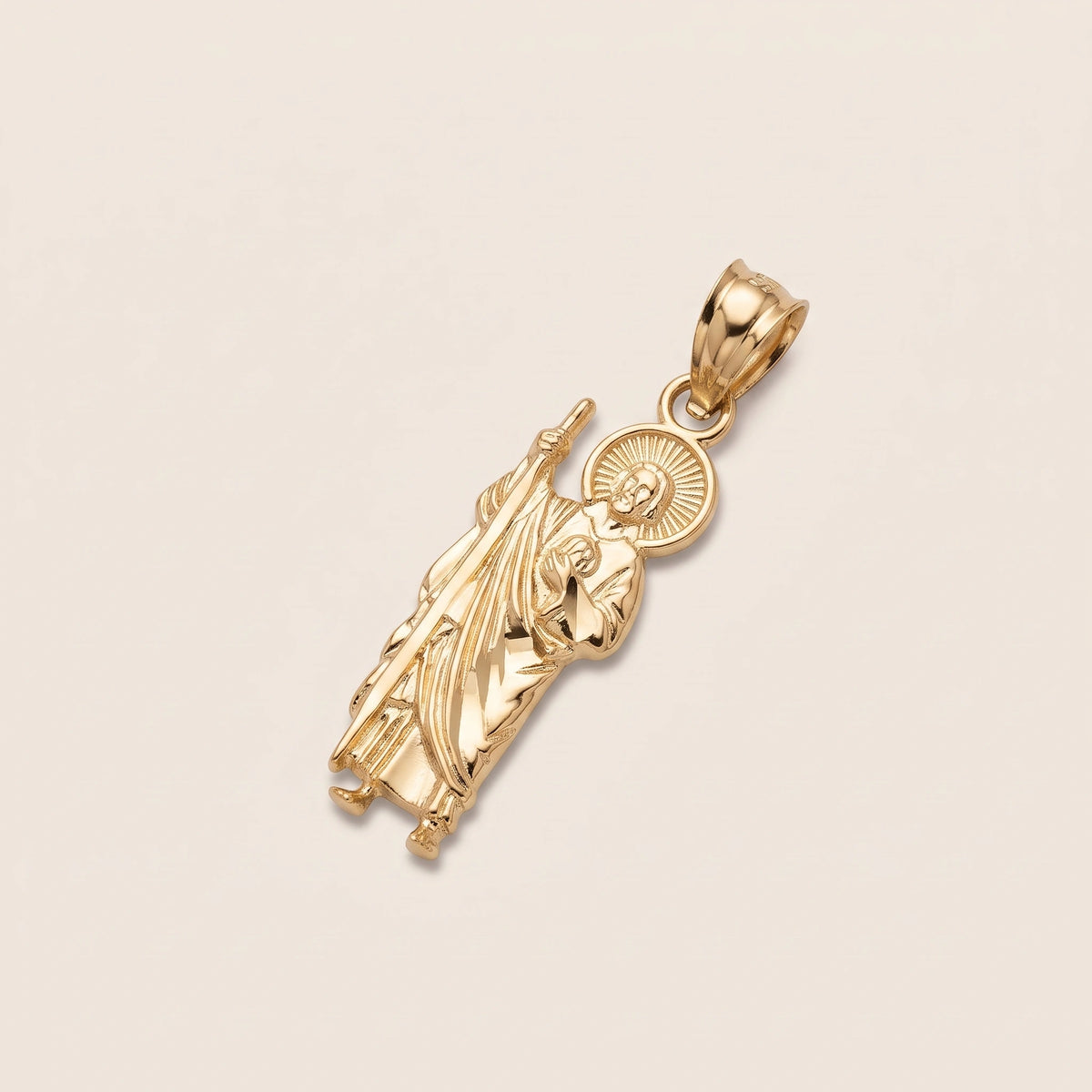 A polished 14K Gold Pendant featuring a detailed relief of St. Jude, with a circular halo motif behind him, shown on a light beige background.