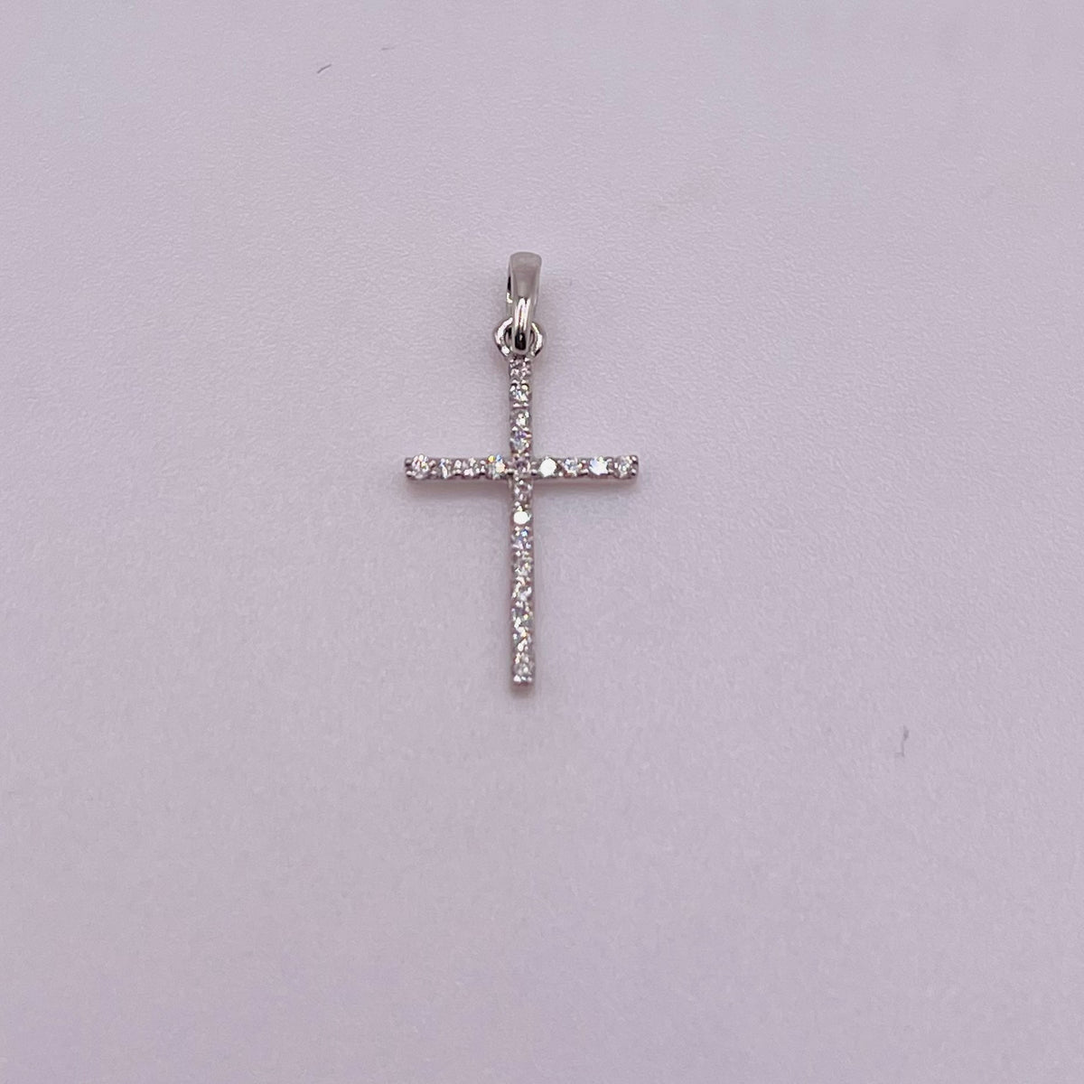 Silver cross pendant on a light gray background