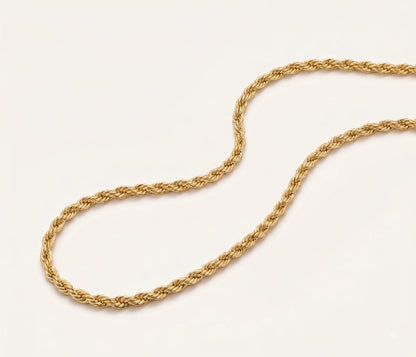 A close-up of a 10K Gold 3mm Solid DC Rope Chain arranged in a loop on a plain off-white background.