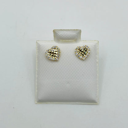 A pair of 10k gold mini heart-shaped earrings with cubic zirconia border, displayed on a white cushion.