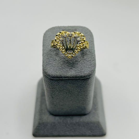 Gold ring with heart design on a gray stand against a light gray background