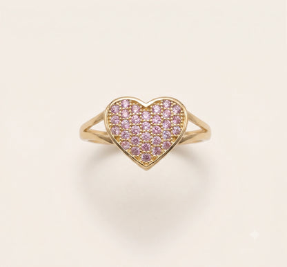 A 10K Gold Domed Heart Ring ring with a pavé setting of small pink cubic zirconias, shown on a clean off-white background.