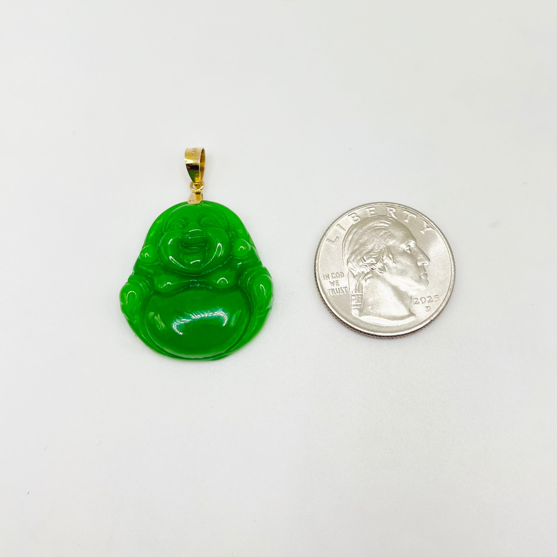 Green Buddha pendant with gold chain next to a U.S. quarter on a white background