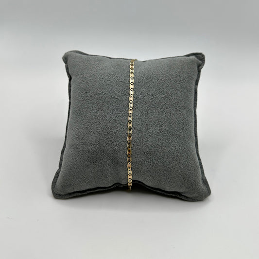 Gray pillow with a gold chain on a light gray background