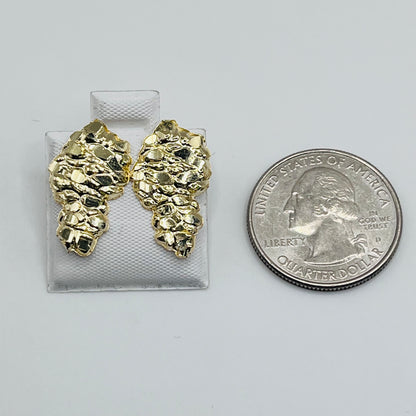 A pair of 10K gold domed nugget-shaped earrings next to a quarter for size comparison on a white background.